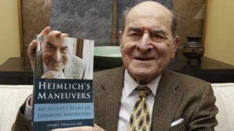 Dr. Henry Heimlich has died in Ohio at age 96. He's seen here in 2014, holding a copy of his memoir at his home in Cincinnati. Al Behrman/AP
