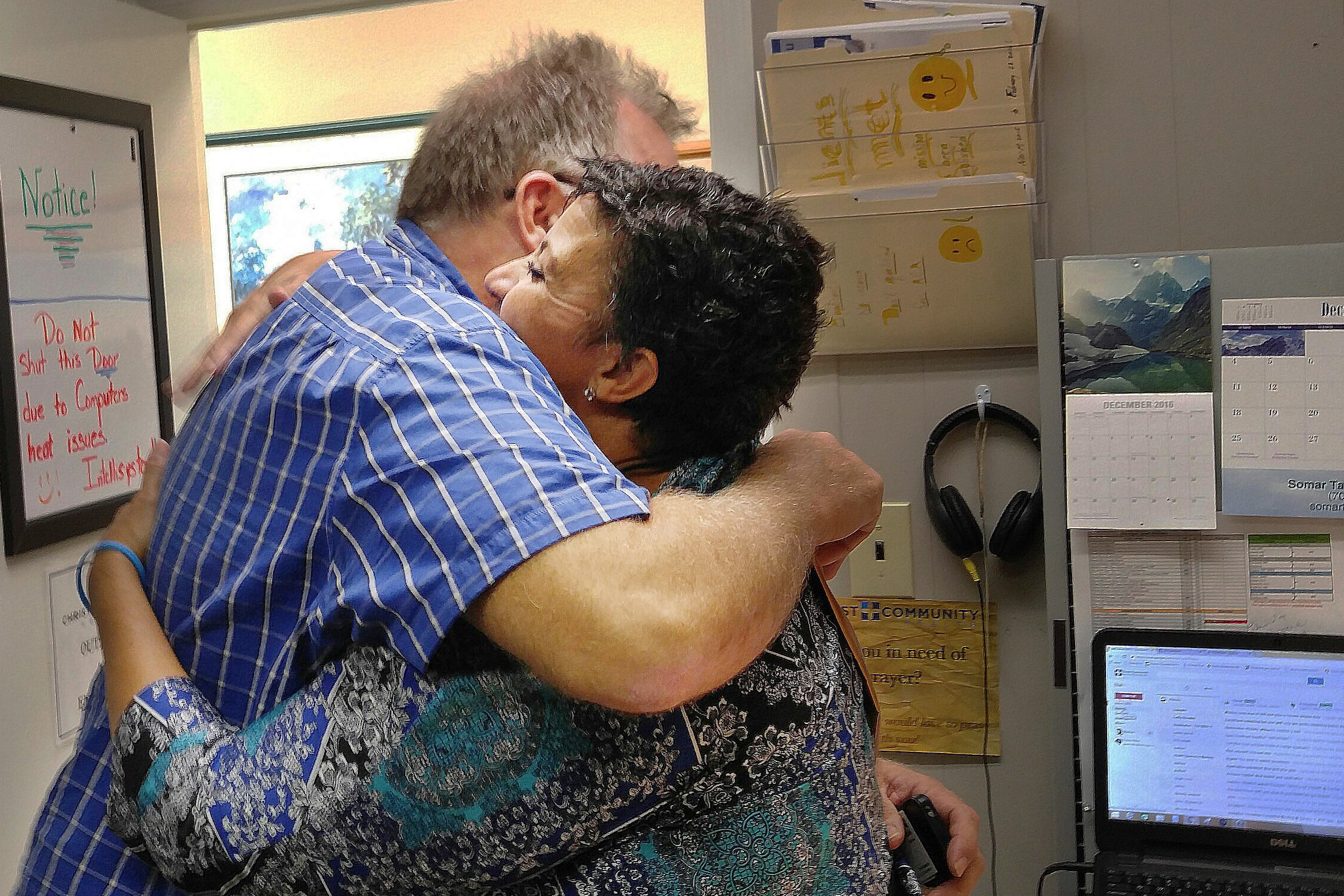 Ron Ellis of Augusta, Ga., hugs Monica Baldwin, a navigator with Christ Community Health, after she helped him sign up for insurance through the Affordable Care Act. (Photo by Phil Galewitz/Kaiser Health News)