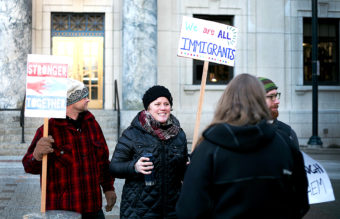 Protesters chat Monday morning, Jan. 30, 2017, in front of the Alaska State Capitol Building in downtown Juneau, Alaska. Protest organizers Jill Weitz and Dan Kirkwood estimate that about 175 people stood at the steps to support refugees and immigrants in the wake of President Donald Trump's executive orders heavily restricting immigration. (Photo by Tripp J Crouse/KTOO)