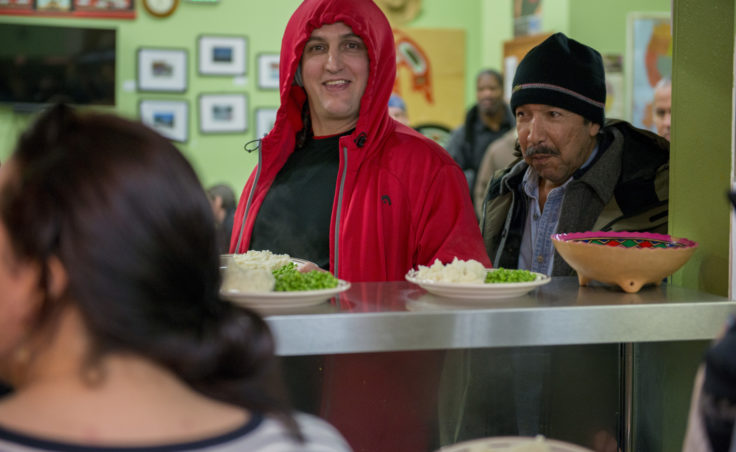 Patrons at the Glory Hole soup kitchen and shelter line up for dinner on Friday, Dec. 30, 2016.