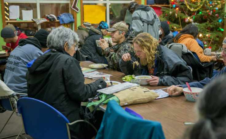 Patrons of the Glory Hole soup kitchen and shelter eat dinner on Friday, Dec. 30, 2016.