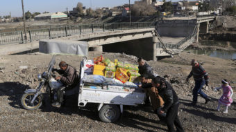 Men push a cart at a makeshift river crossing next to a bridge destroyed by Islamic State militants in Mosul, Iraq, on Thursday. The Iraqi forces have reclaimed much of eastern Mosul, but the Islamic State still controls much of the western side of the city.