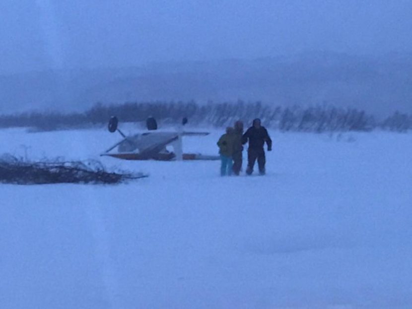 Three people walk away after their Cessna 180 crashed near a ridgeline landing strip in the vicinity of the Chakachatna River in the Kenai Peninsula, Alaska, Jan. 30, 2017. A Coast Guard Air Station Kodiak MH-60T Jayhawk crew transported the three to Anchorage International Airport. (Photo by U.S. Coast Guard)