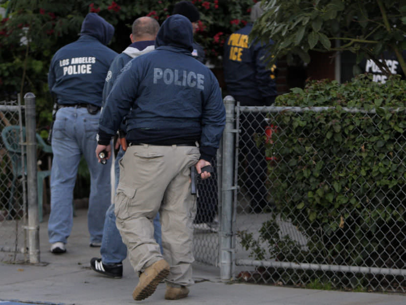 U.S. Immigration and Customs Enforcement officers and Los Angeles police officers enter a house during a joint operation in 2009.