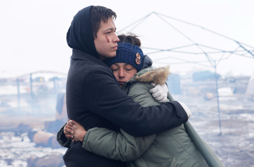 Alex Redbear and Kateri Eagle Staff embrace during a prayer ceremony at the Oceti Sakowin camp on Monday. (Photo by Angus Mordant for NPR)