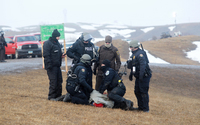 Police make arrests as they move south on highway 1806, just outside the entrance to the Oceti Sakowin camp on Monday. (Photo by Angus Mordant for NPR)