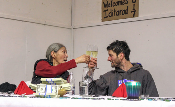 Nicolas Petit and Tanana resident Blanche Edwin enjoy the five-course meal Petit won for being the first musher to the Yukon River. (Photo by Ben Matheson/KNOM)