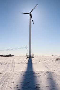 A wind turbine stands outside the Yukon-Kuskokwim Fitness Center. Alaska Village Electric Cooperative plans to erect a larger 900 kilowatt wind turbine near the Bethel airport in 2018. (Photo by Dean Swope/KYUK)