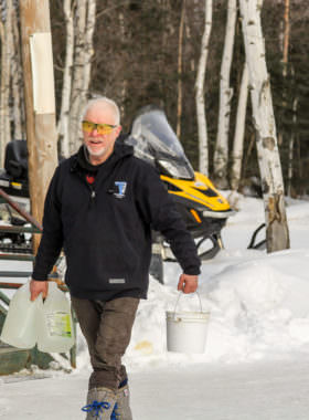 Jeff King bringing water to his team in Galena during the Iditarod. (Photo by Zachariah Hughes/Alaska Public Media)