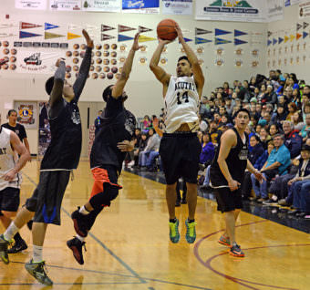 Yakutat's Martin Sensmeier (14) shoots over Angoon defenders during their B Bracket elimination game at the Juneau Lions Club 69th Gold Medal Basketball Tournament in 2015.