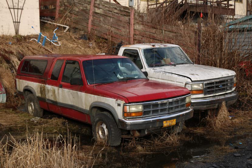 Old trucks are parked in the bushes in Wrangell. The Southeast city is one of eight working on a group agreement to collect and barge old vehicles and other scrap metal south for recycling. (Photo by Aaron Bolton/KSTK)