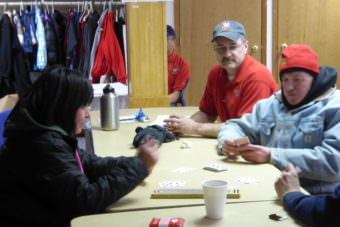 Lt. Lance Walters, middle right, watches a card game at the warming station in the Salvation Army church on Saturday.