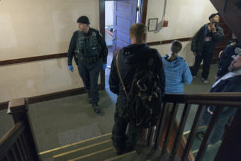 Juneau police and community members look on as residents of the Bergmann Hotel hurriedly packed their belongings and left their rooms on Friday March 10, 2017 in Juneau, Alaska. The building has been condemned and residents were given 24-hours to leave. (Photo by Rashah McChesney/Alaska's Energy Desk)