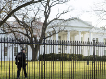 A member of the Secret Service walks the perimeter of the North Lawn of the White House in Washington, last March. On Friday night, an intruder entered the White House grounds while the President was home. Andrew Harnik/AP