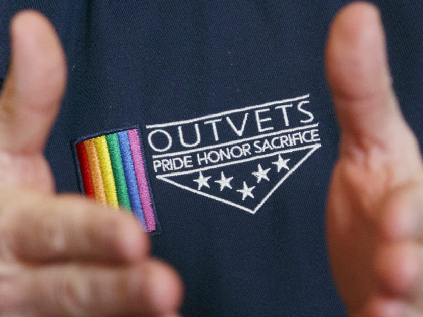 OutVets founder Bryan Bishop wears the logo of his group while speaking in Boston. The group has been invited to participate in the city's privately-run St. Patrick's Day parade. Michael Dwyer/AP