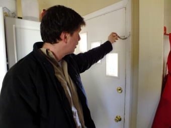 Juneau resident David Noon resets the chain on the back door of his home. When his place was burglarized in October, the chain was not set and the burglar was able to kick in the door because the deadbolt lock did not fully extend into the door jamb. The door, door jamb, and the deadbolt have since been repaired.