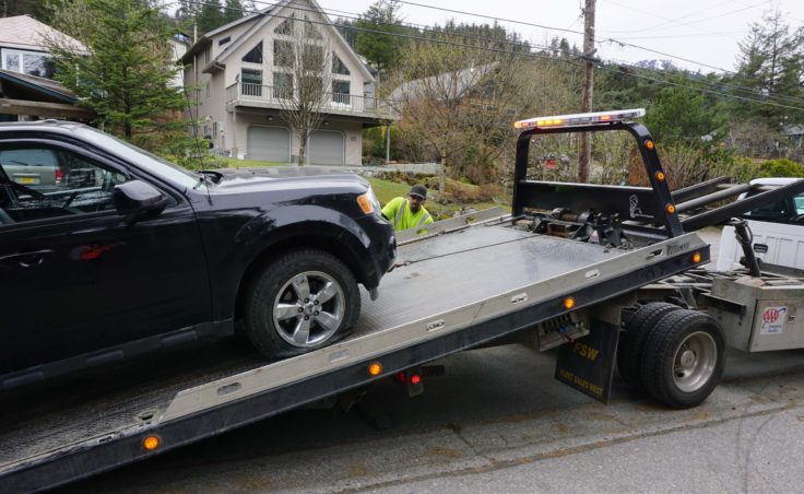 Randal Benc of Capital Towing runs the winch pulling a truck onto the flatbed on Douglas Highway in West Juneau, Wednesday, April 26, 2017.