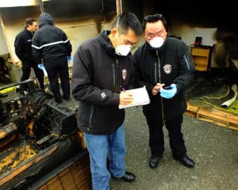 Student investigators from the North Slope Borough Fire Department confer while investigating a staged fire during a recent fire investigator training exercise at Juneau’s Hagevig Regional Fire Training Center. (Photo by Matt Miller/KTOO)