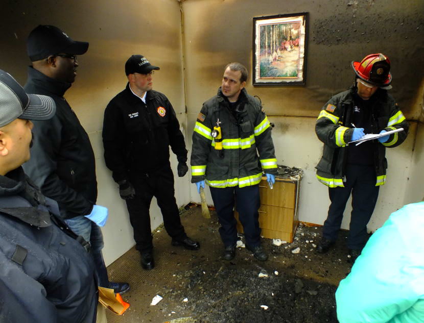 Instructors and student investigators talk about the investigative process in the aftermath of a fire in staged room at Juneau’s Hagevig Regional Fire Training Center. (Photo by Matt Miller/KTOO)