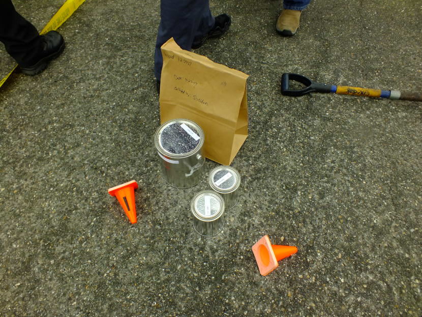A bag containing clothing awaits processing as possible evidence during a recent fire investigator’s training exercise at Juneau’s Hagevig Regional Fire Training Center. The cans contain the potential ignition source and the gloves used by the investigator to pick up the evidence. (Photo by Matt Miller/KTOO)