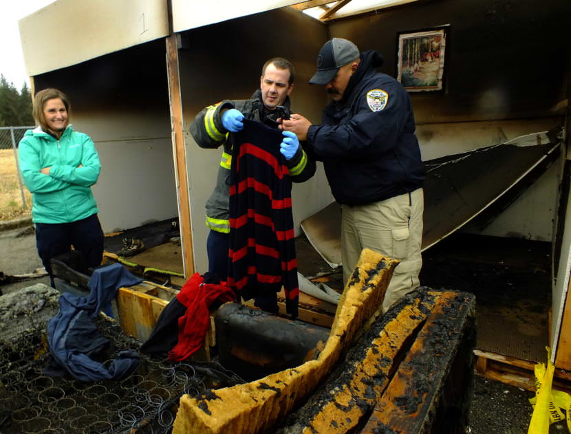 Student investigators take pictures of clothing which may provide clues about the cause and origin of a fire during a recent fire investigator’s training exercise at Juneau’s Hagevig Regional Fire Training Center. (Photo by Matt Miller/KTOO)