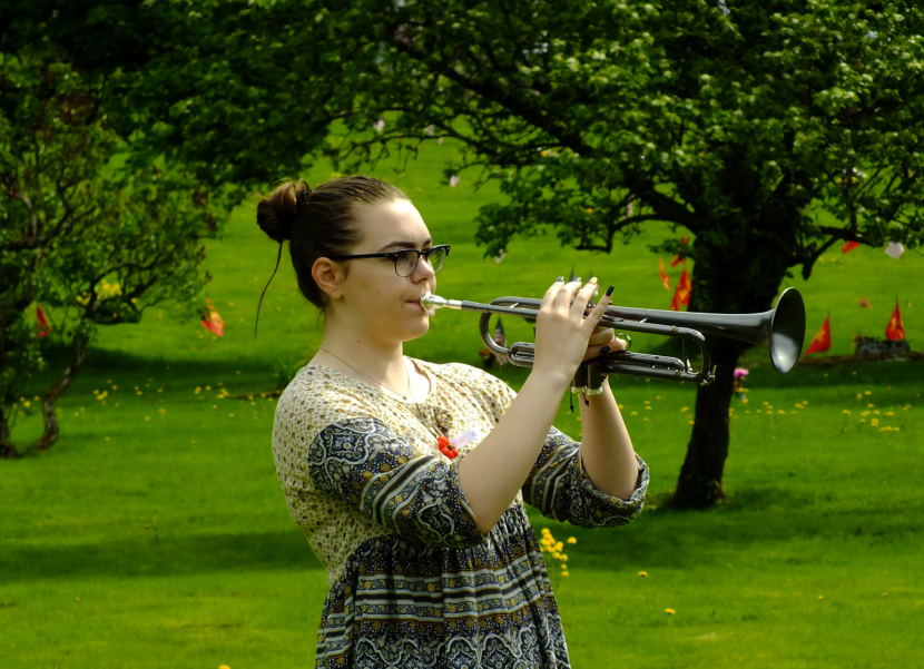 Jessica Cooper, a rising senior at Thunder Mountain High School, plays taps during the 2017 Memorial Day observance at Evergreen Cemetery. (Photo by Matt Miller/KTOO)