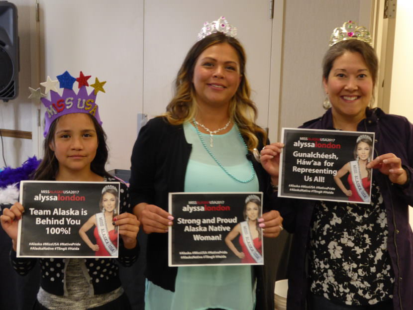 Sierra Flores, left, her mother Serena Hinchman and Raeanna Holmes holds signs at the Miss USA watch party in the Elizabeth Peratrovich Hall in Juneau on Sunday, May 14, 2017. Hinchman and Holmes work for Central Council of the Tlingit and Haida Indian Tribes. of Alaska.