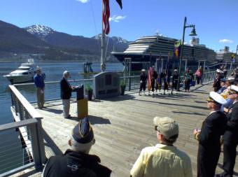 Juneau Mayor Ken Koelsch (at podium) speaks during a memorial service for USS Juneau on the downtown waterfront on Tuesday, May 16, 2017. Juneau Port Director Carl Uchytil listens at far left.