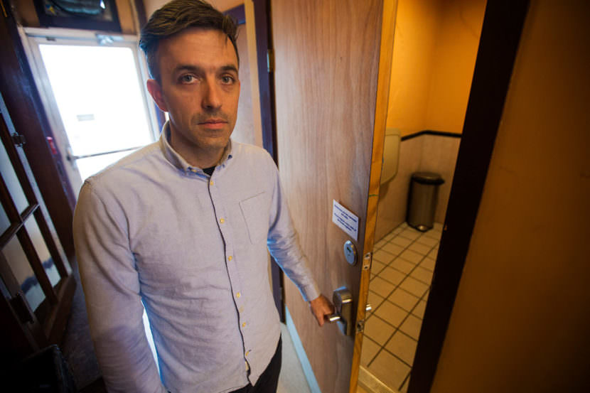 1369 Coffee House owner Josh Gerber opens the bathroom door, which has a combination lock given to patrons at the front counter.