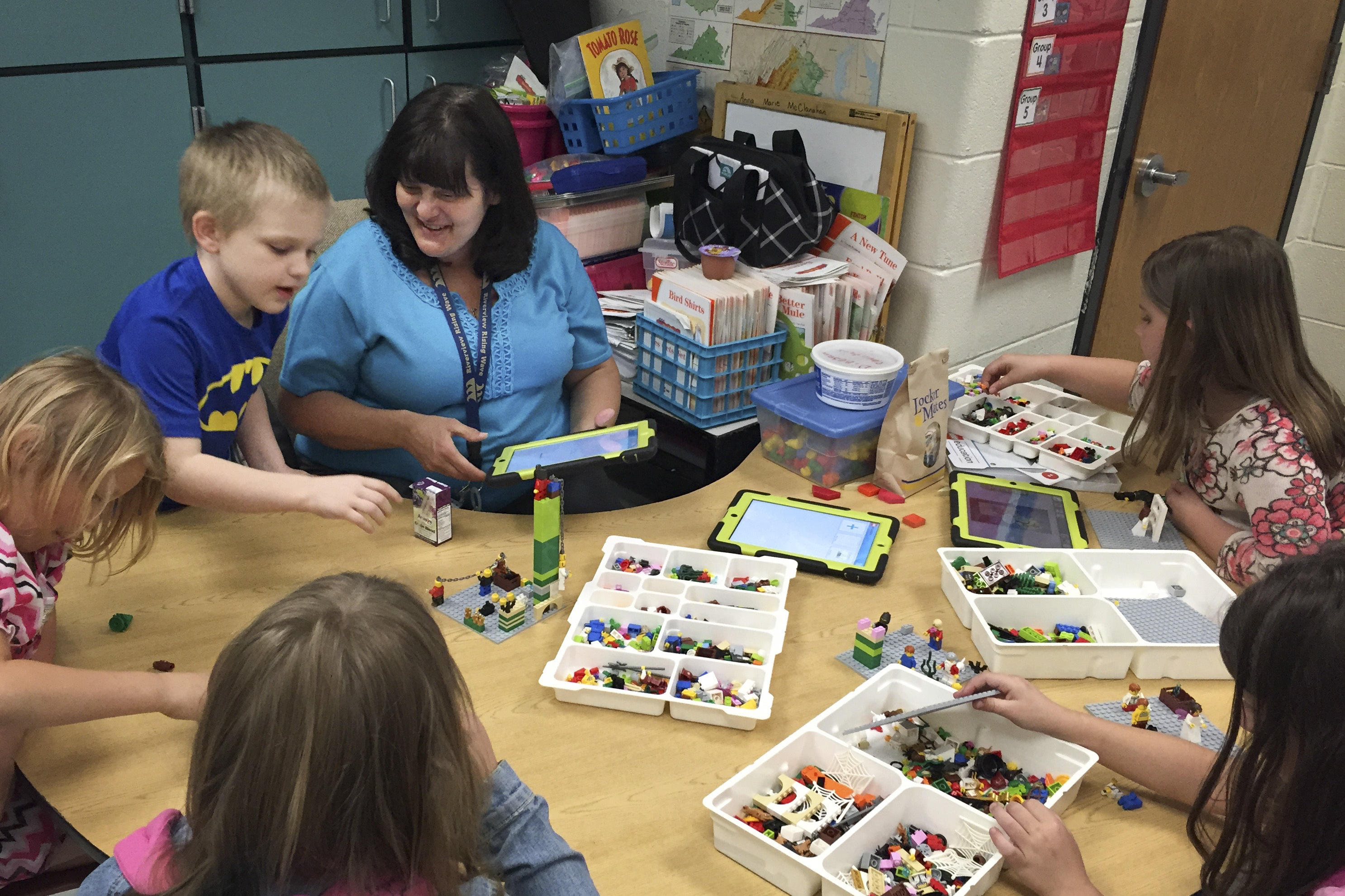 Anna Marie McClanahan (center) helps children write stories by using Legos to create scenes. (Photo by Pam Fessler, NPR)
