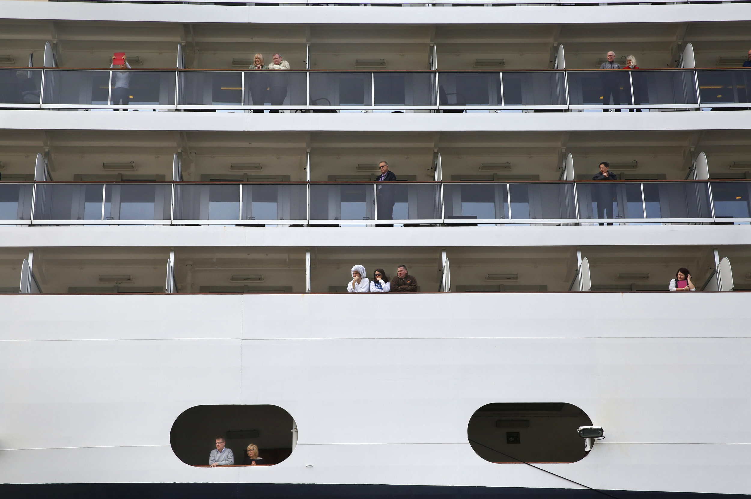Passengers aboard the Nieuw Amsterdam cruise ship look out at Ketchikan. (Photo by Elissa Nadworny/NPR)