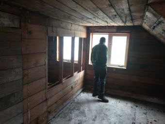 Don Andrew Roguska looks out from an upstairs window of an historic Juneau house he bought in 2016 to restore. Zoning regulations have prevented him from rebuilding in the same style. (Photo by Jacob Resneck/KTOO)