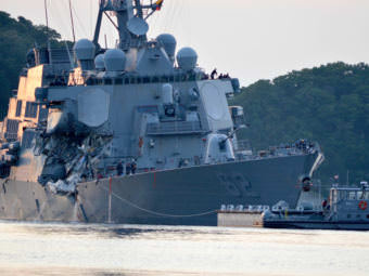 The guided missile destroyer USS Fitzgerald returns to Yokosuka, Japan, after its collision Saturday. Authorities say the ship's flooding "has been stabilized," but seven sailors remain unaccounted for.