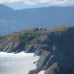 View of the summit of Mount Juneau in 2009 with the shipping containers, unfinished bunkhouse and abandoned backhoe. (Photo courtesy of Trail Mix)