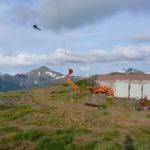 Pieces of the backhoe are lifted by helicopter from the summit of Mount Juneau in 2009. (Photo courtesy of Trail Mix)