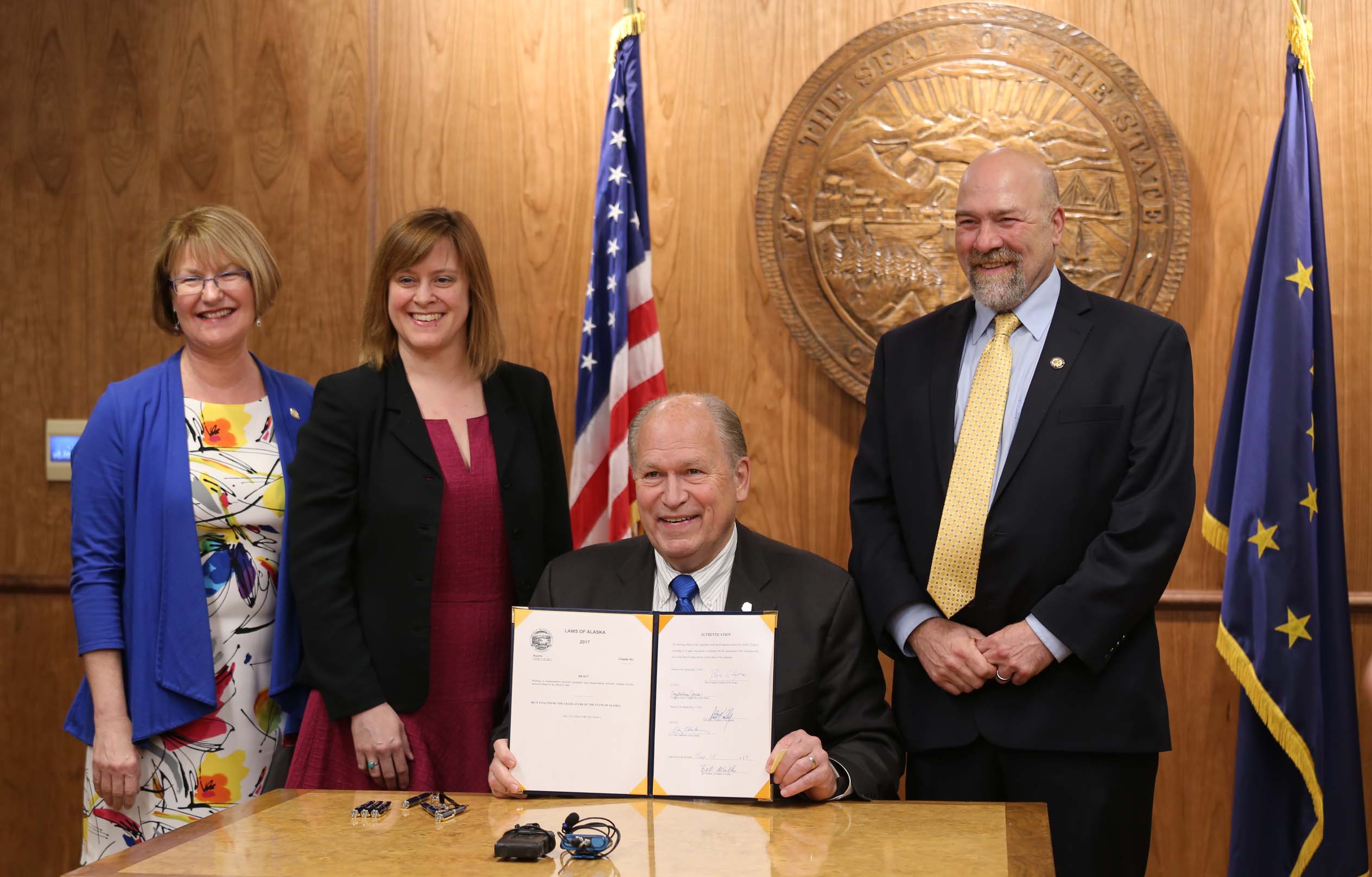 Alaska Gov. Bill Walker shows off House Bill 132 after signing the ridesharing measure into law in Juneau on June 15, 2017.