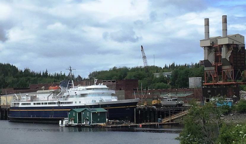 The Alaska Marine Highway System ferry Taku is in storage at Ketchikan's Ward Cove. The former Ketchikan Pulp Co. mill site, including ferry headquarters, is in the background. (Photo by Leila Kheiry/KRBD)