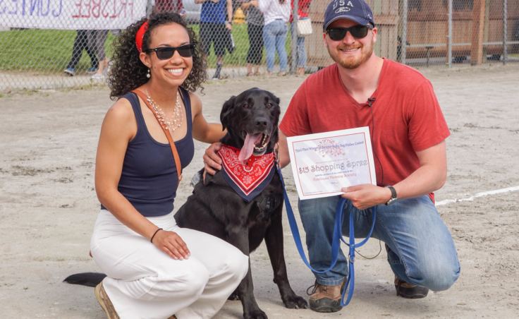 Brandy Scott, Butch the black Lab, and Eric Scott pose for the cameras after taking third place in the Super Dog Frisbee Contest in Douglas on July 4, 2016. (Photo by Jeremy Hsieh/KTOO)