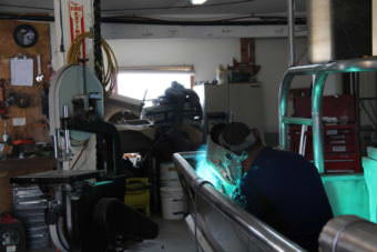 George Wilson puts the finishing touches on the second skiff Fishy Fabrications has built this spring. (Photo by KDLG)