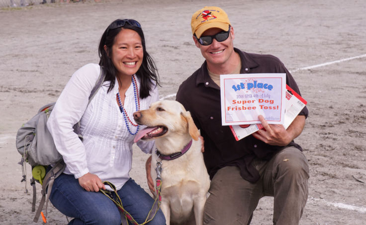 Lisa Phu, Lota the yellow lab and Scott Forbes pose for the cameras after winning the Super Dog Frisbee contest in Douglas on July 4, 2016.