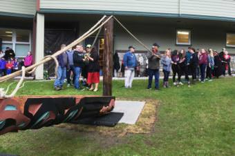 Schoenbar Middle School students and visitors prepare to raise the Pathfinder totem pole. (Photo by Leila Kheiry/KRBD)