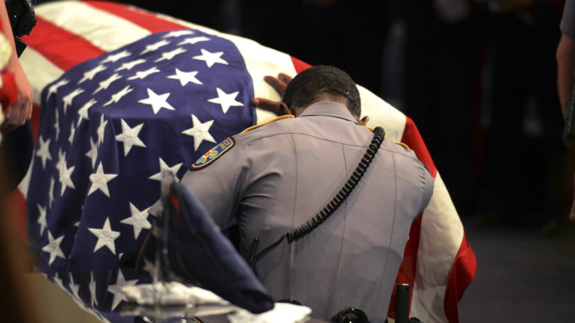 A Baton Rouge police officer kneels at the casket of Cpl. Montrell Jackson, one of three officers ambushed and killed by a gunman July 17, 2016.