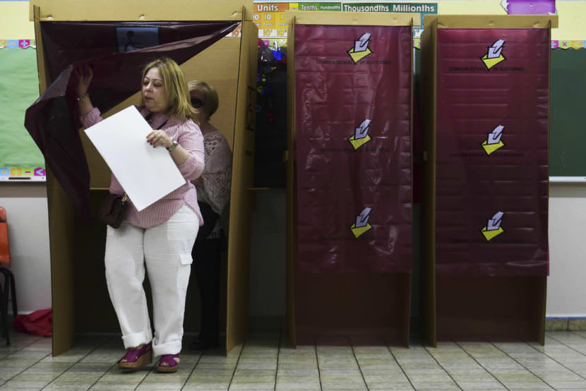 A woman exits the voting booth in San Juan during Puerto Rico's non-binding referendum Sunday. Puerto Rican voters are weighing whether to ask Congress for statehood.