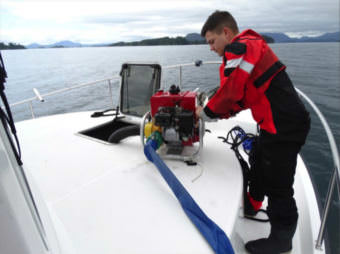 Petty Officer 2nd Class Derrick Depriest, a damage controlman on board the Coast Guard Cutter John McCormick, operates a P-6 pump to combat flooding in the forward living quarters of a tug that ran aground on the Vitskari Rocks, near Sitka, Alaska, June 10, 2017. A McCormick smallboat crew and an Alaska State Trooper few responded to the tug after Coast Guard Sector Juneau watchstanders received a report on VHF-FM radio channel 16 from the tug crew that they had run aground and were taking on water. (Photo courtesy U.S. Coast Guard)