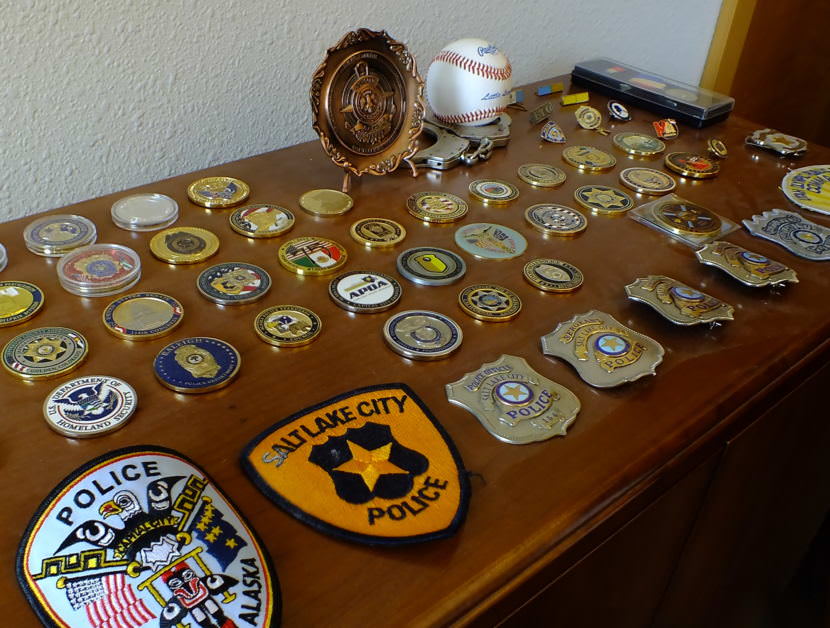 A collection of patches, badges, pins and challenge medals line the top of a cabinet in Juneau Police Chief Bryce Johnson's office. He still has the baseball that he threw out as part of the ceremonial first pitch during Little League opening day immediately following his arrival in Juneau.