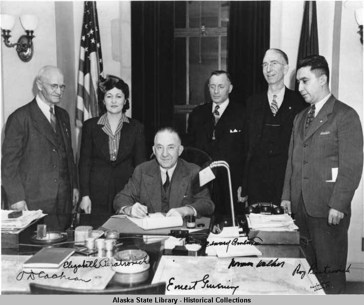 Then-Alaska Gov. Gruening signs the Anti-Discrimination Act of 1945, as O.D. Cochran, left, Elizabeth Peratrovich, Edward Anderson, Norman Walker and Roy Peratrovich stand behind him. (Photo courtesy Alaska State Library Photo Collection, P01-3294)
