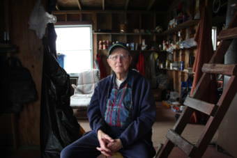 Doug Cooper sits in his cabin on Nushagak Point. (Photo by Nick Ciolino/KDLG)