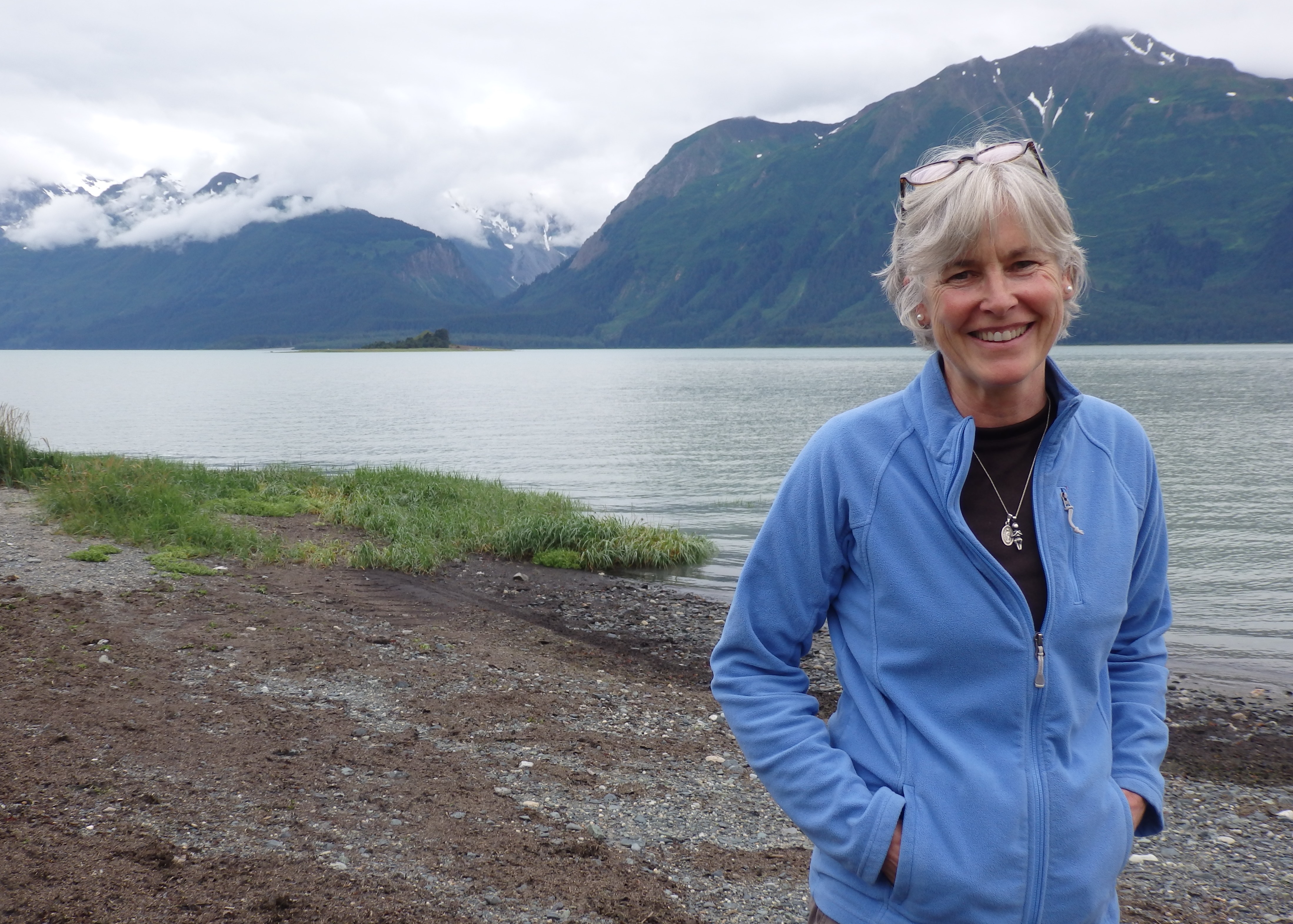 Heather Lende stands on the beach outside her home in Haines. (Photo by Emily Files/KHNS)