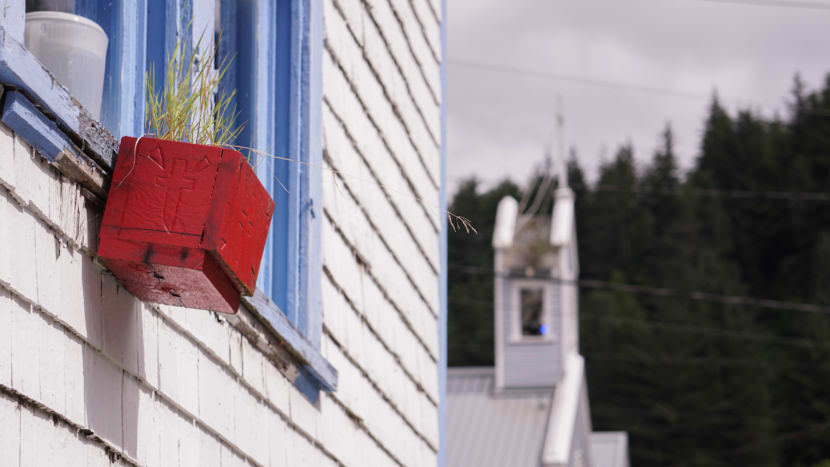 Grass grows in a planter off a window of St. Nicholas Russian Orthodox Church in downtown Juneau on July 15, 2017. The Catholic Cathedral of the Nativity of the Blessed Virgin Mary is in the background. (Photo by Jeremy Hsieh/KTOO)