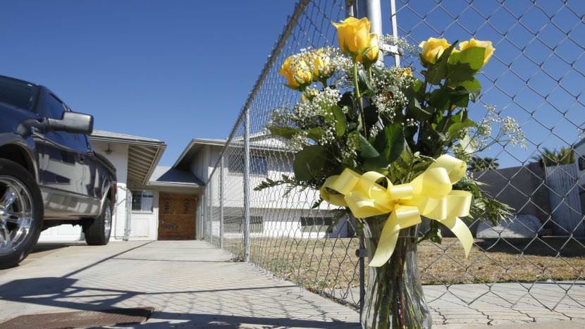 A lone bouquet of flowers stands in front of a home in Phoenix in 2013, after police said a man killed his wife, daughter and brother-in-law before killing himself. A new CDC report sheds light on patterns in homicides of women.